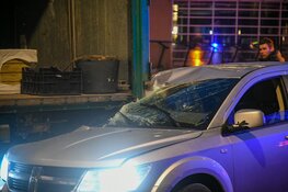 Auto botst achterop lossende vrachtwagen in Hilversum
