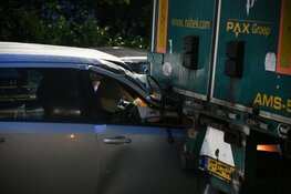 Auto botst achterop lossende vrachtwagen in Hilversum