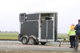 Paardentrailer waait om, vrachtwagen rijdt zich vast