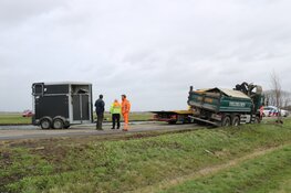 Paardentrailer waait om, vrachtwagen rijdt zich vast