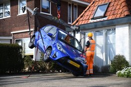 Automobilist rijdt per ongeluk achteruit en komt met voertuig vast in heg te zitten
