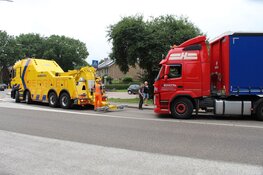 Vrachtwagen rijdt zich vast in het gras in Huizen