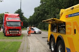 Vrachtwagen rijdt zich vast in het gras in Huizen