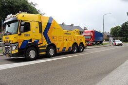 Vrachtwagen rijdt zich vast in het gras in Huizen