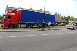 Vrachtwagen rijdt zich vast in het gras in Huizen