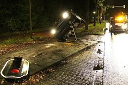 Auto rijdt stoplicht uit de grond in Huizen