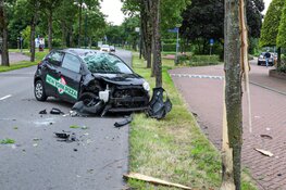 Pizzabezorger knalt met auto tegen boom en gaat over de kop in Huizen