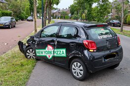 Pizzabezorger knalt met auto tegen boom en gaat over de kop in Huizen
