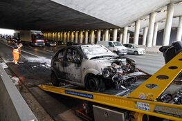 Auto in brand onder viaduct bij Muiden