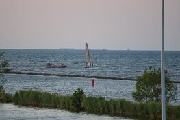 Catamaran omgeslagen vlak voor haven van Muiden
