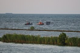 Catamaran omgeslagen vlak voor haven van Muiden