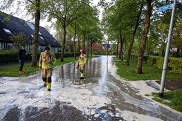 Straat onder water in Huizen na gesprongen waterleiding