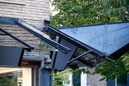 Bakwagen rijdt tegen afdakje winkel in Huizen