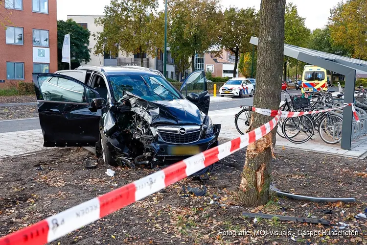 Auto botst hard tegen boom in Huizen, twee gewonden