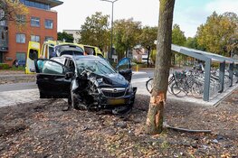 Auto botst hard tegen boom in Huizen, twee gewonden