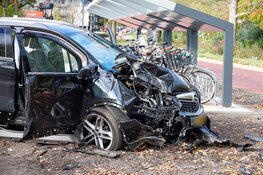 Auto botst hard tegen boom in Huizen, twee gewonden