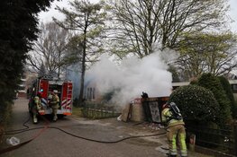 Grote bouwcontainer tegen woning in vlammen opgegaan