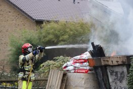 Grote bouwcontainer tegen woning in vlammen opgegaan