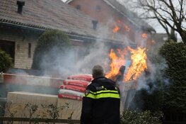 Grote bouwcontainer tegen woning in vlammen opgegaan