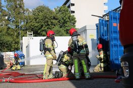 Brandweer haalt gasflessen uit brandende container