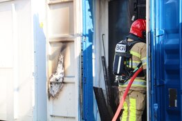Brandweer haalt gasflessen uit brandende container