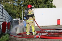 Brandweer haalt gasflessen uit brandende container