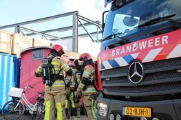 Brandweer haalt gasflessen uit brandende container