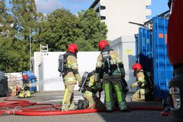 Brandweer haalt gasflessen uit brandende container