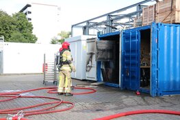 Brandweer haalt gasflessen uit brandende container