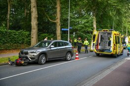Scooter half onder auto in Hilversum