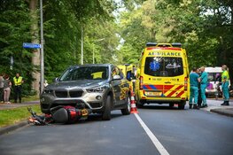 Scooter half onder auto in Hilversum