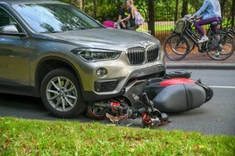 Scooter half onder auto in Hilversum